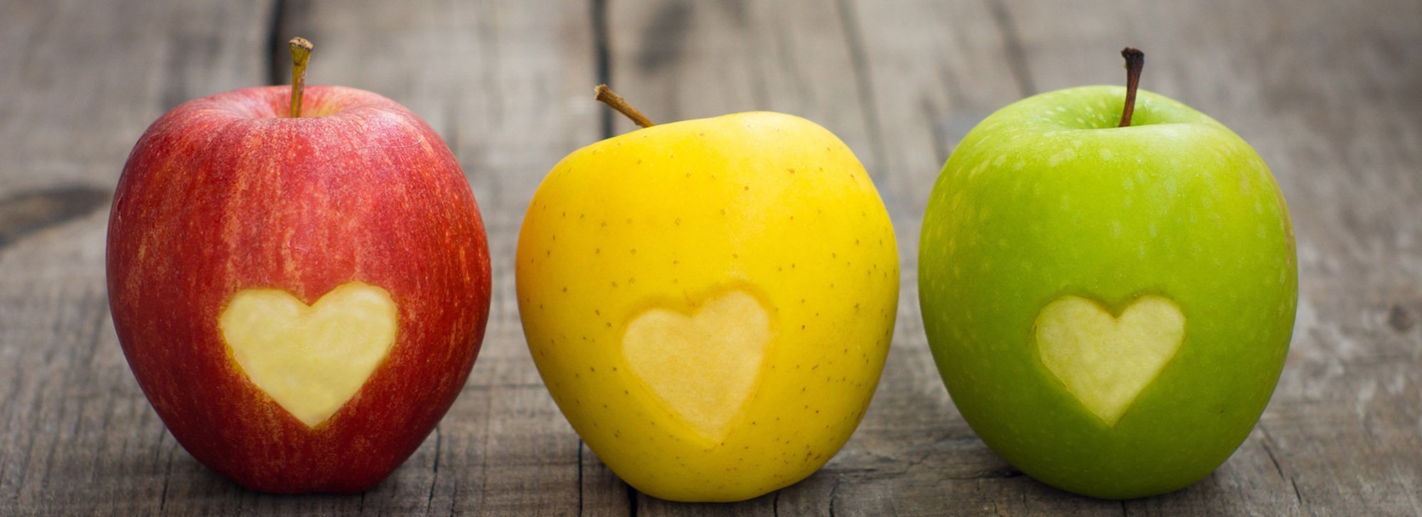 Apples with engraved hearts Three apples with engraved hearts on wood background