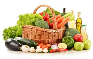 Composition with raw vegetables in wicker basket isolated on white